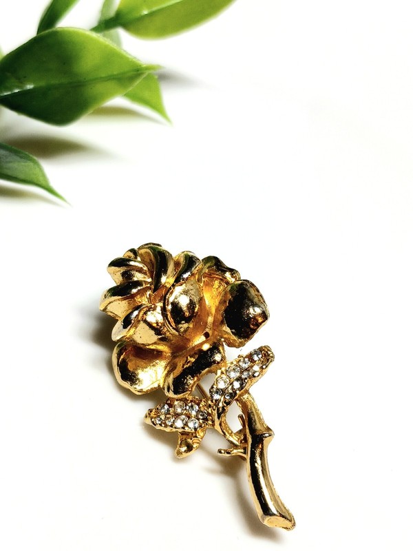 Vintage gold-tone rose brooch with crystal accents.